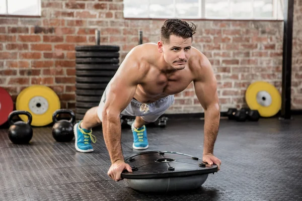 Muscular man doing bosu push ups — Stock Photo, Image