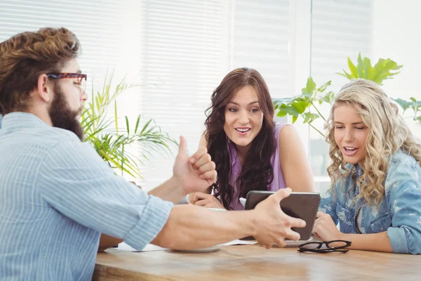 Man showing digital tablet to happy coworkers — Stock Photo, Image