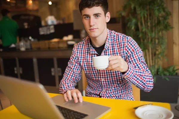 Portrét mladého muže s kávou pomocí přenosného počítače — Stock fotografie