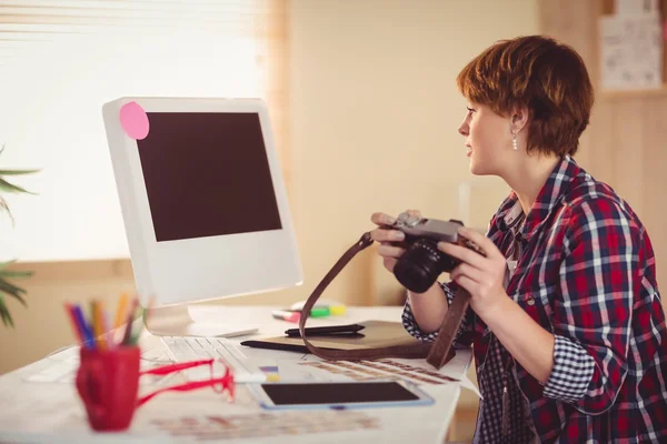 Zaměřením fotograf hledá fotky na počítači — Stock fotografie