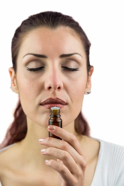 Close-up of woman smelling bottle of medicine — Stock Photo, Image