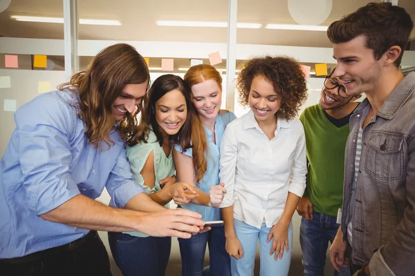 Empresario mostrando teléfono a colegas felices — Foto de Stock