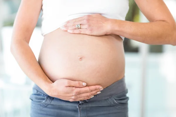 Buik van vrouw met handen op een buik — Stockfoto