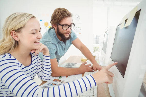 Mujer sonriente apuntando a la computadora — Foto de Stock