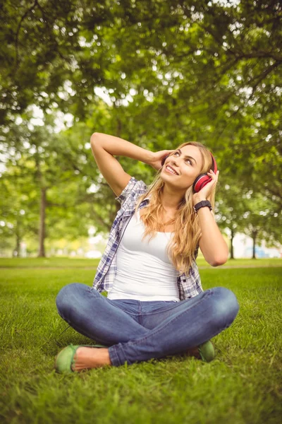 Full längd av glad kvinna njuter av musik på park — Stockfoto