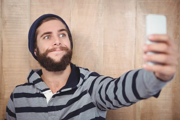 Hipster haciendo cara mientras toma selfie en el teléfono móvil — Foto de Stock