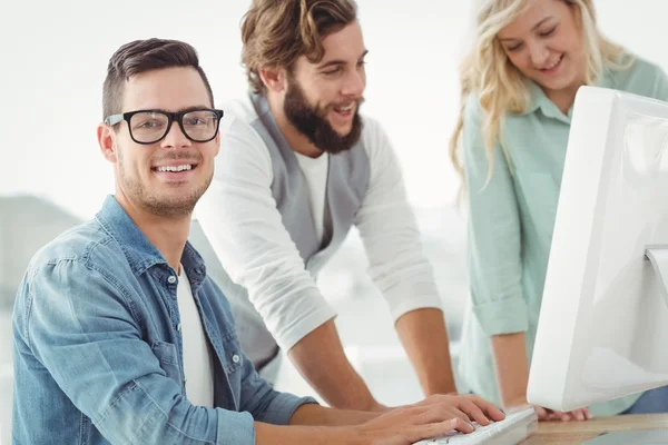 Portret van lachende man bij computerbureau — Stockfoto