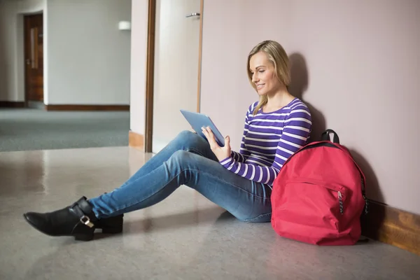 Kvinnlig student leende medan du använder digital tablet — Stockfoto