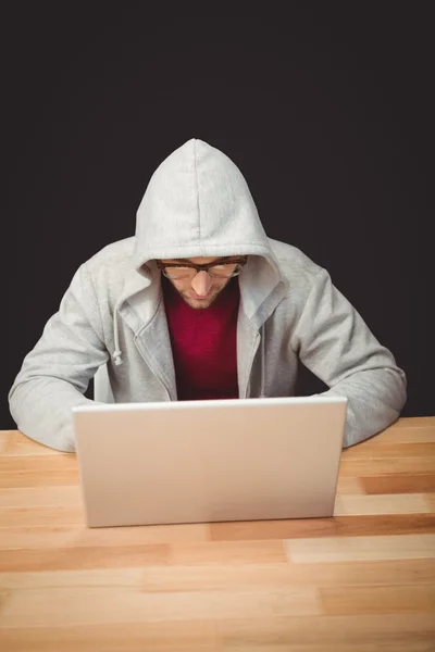 Mann mit Kapuzenshirt arbeitet an Laptop — Stockfoto