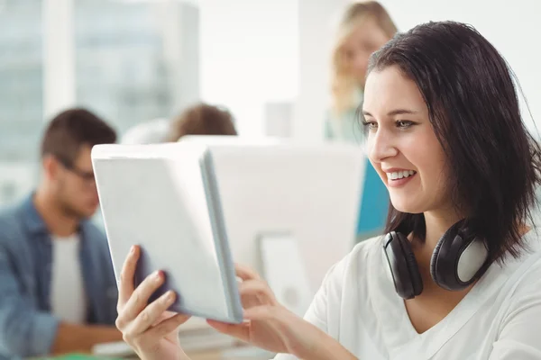 Usmívající se žena s sluchátka pomocí digitálních tabletu — Stock fotografie