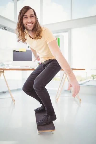 Hipster uśmiechający się podczas jazdy na deskorolce — Zdjęcie stockowe