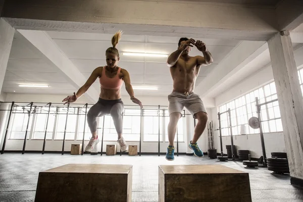 Fit couple doing set of box jumps — Stock Photo, Image
