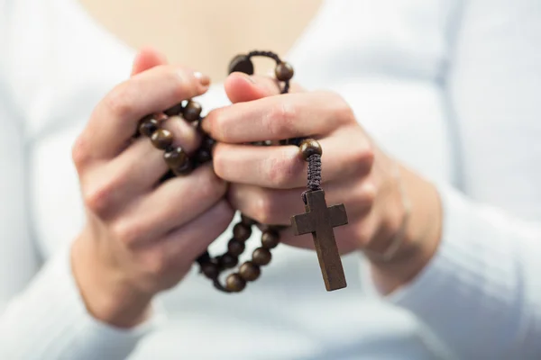 Woman holding rosary beads — Stock Photo, Image