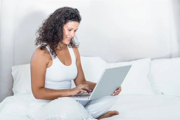 Piękna kobieta w ciąży uśmiechający się za pomocą laptopa — Zdjęcie stockowe