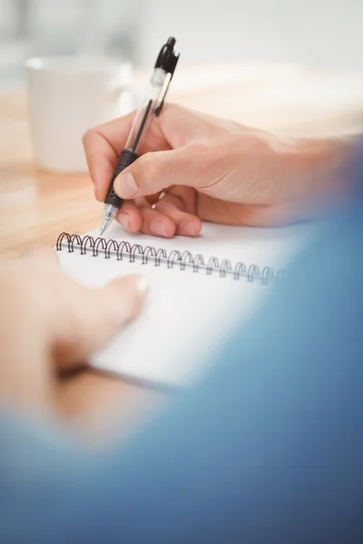 Homme d'affaires écrivant sur la table en spirale au bureau — Photo