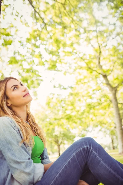 Lächelnde Frau blickt in Park auf — Stockfoto