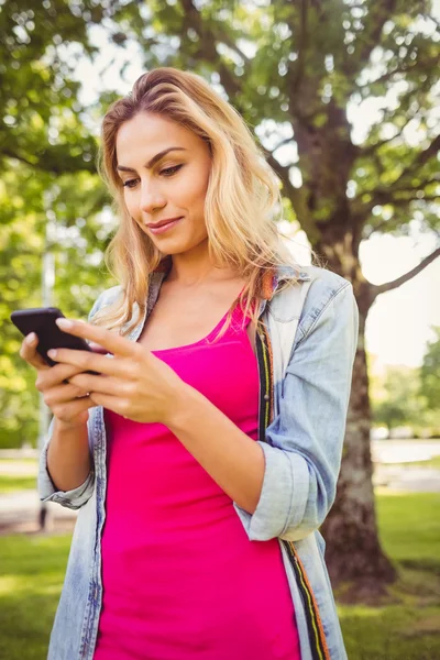 Glückliche Frau nutzt Smartphone im Park — Stockfoto