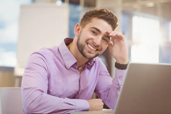 Homme d'affaires souriant travaillant avec un ordinateur portable — Photo