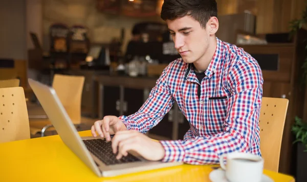 Młody człowiek korzysta z laptopa na stole — Zdjęcie stockowe