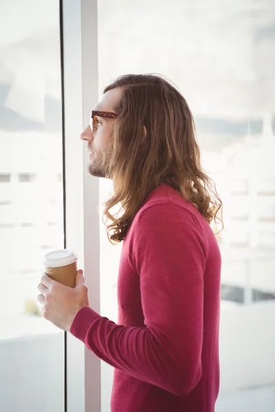 Vista laterale dell'uomo che tiene la tazza usa e getta in ufficio — Foto Stock