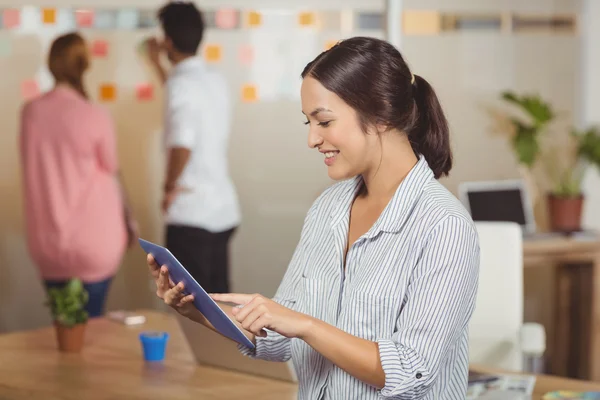 Feliz mujer de negocios usando tableta digital en la oficina — Foto de Stock