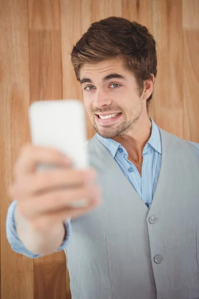 Biznesmen uśmiechający się podczas przyjmowania selfie — Zdjęcie stockowe
