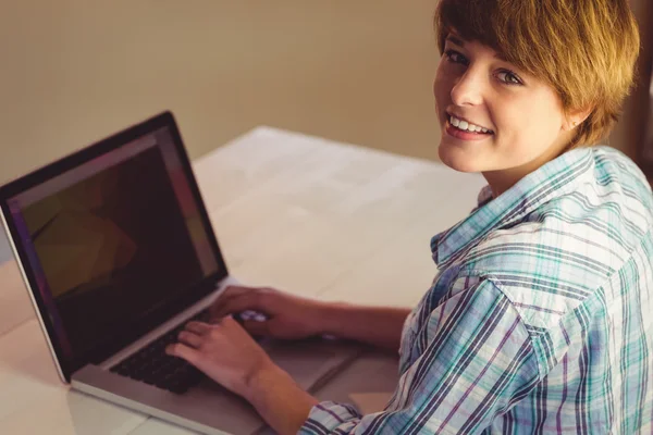 Femme d'affaires souriante utilisant son ordinateur portable au bureau — Photo