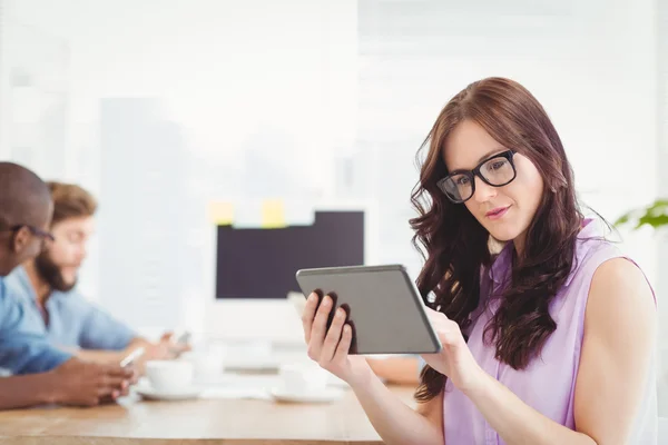 Promyšlené žena držící digitálním tabletu na stůl — Stock fotografie