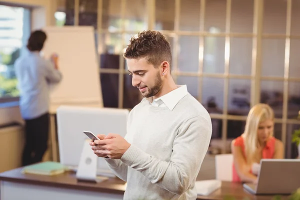 Affärsman textning på telefon med kollegor — Stockfoto