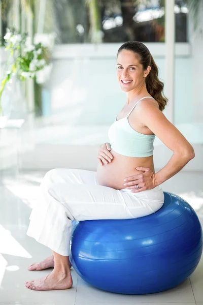 Retrato de mulher feliz sentada na bola de exercício — Fotografia de Stock