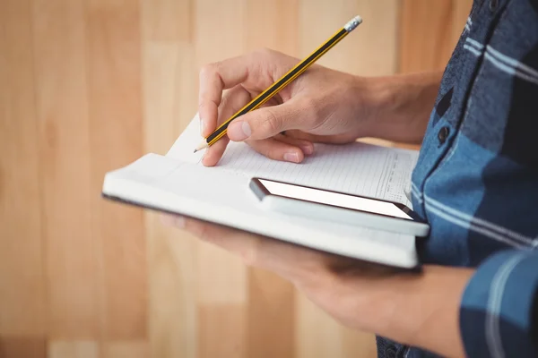 Abgeschnittenes Bild eines Geschäftsmannes, der mit Bleistift auf Buch schreibt — Stockfoto