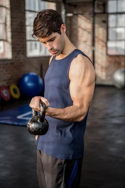 Vista lateral de um homem levantando kettlebell — Fotografia de Stock