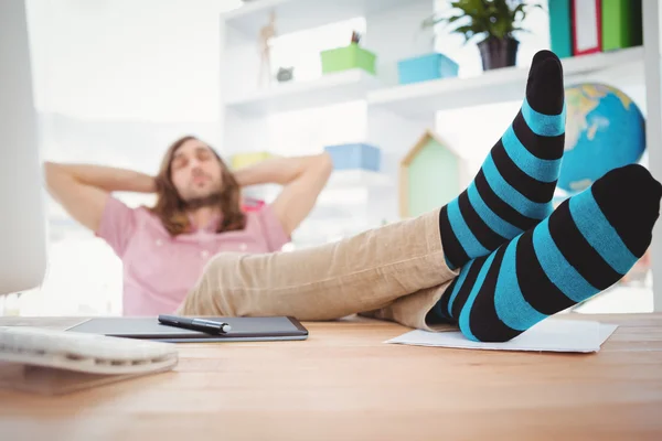 Hipster resting with legs on desk — Stock Photo, Image