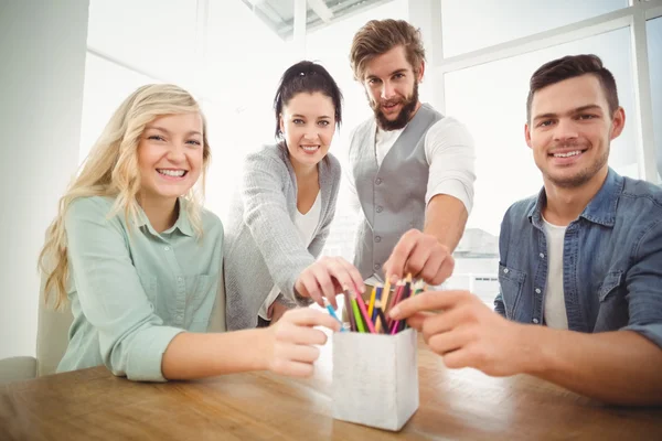 Retrato de pessoas de negócios sorrindo levando lápis de desk org — Fotografia de Stock