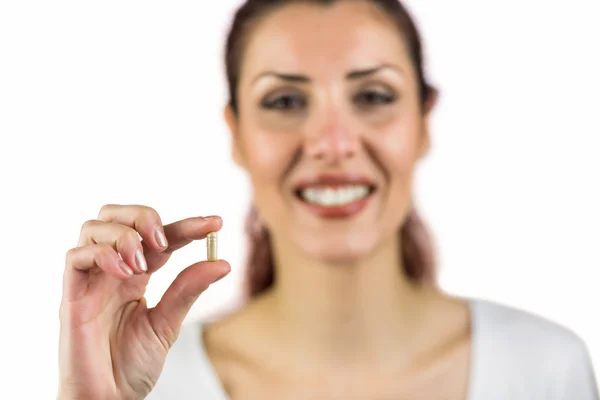 Retrato de cerca de una mujer sonriente sosteniendo la píldora — Foto de Stock