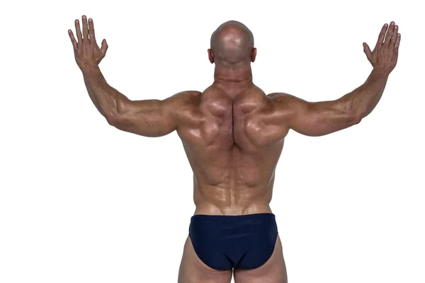 Rear view of muscular man with arms raised — Stock Photo, Image