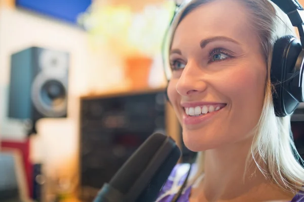 Giovane conduttore radio che indossa le cuffie utilizzando lo studio del microfono — Foto Stock