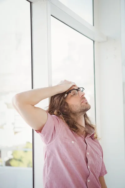 Hipster stanco in piedi con mano sulla testa — Foto Stock