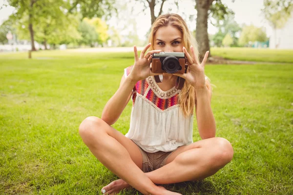 Portrait of woman holding camera in park — Stok Foto