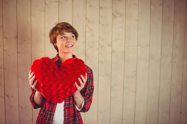 Bella donna che tiene un cuscino del cuore — Foto Stock