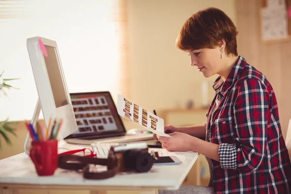 Lachende fotograaf foto's kijken naar haar Bureau — Stockfoto