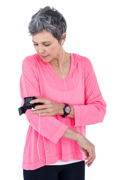 Mulher ajustando braçadeira enquanto ouve música — Fotografia de Stock