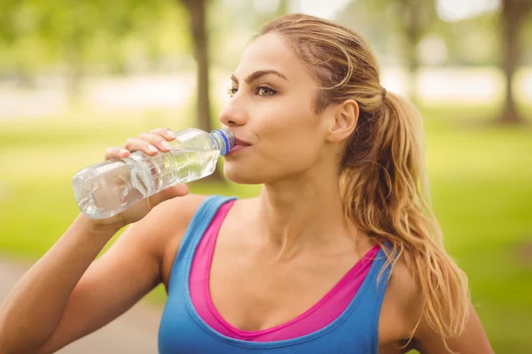 Woman drinking water in park — Stock Photo, Image
