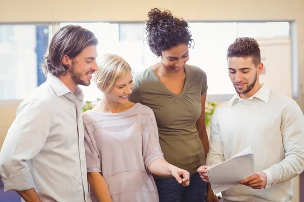 Mensen uit het bedrijfsleven glimlachen en kijken naar vel papier — Stockfoto