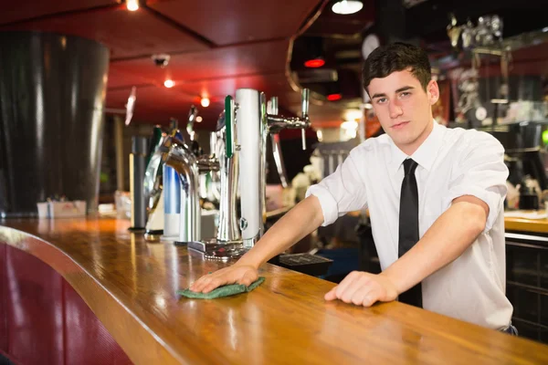 Confident male bartender cleaning bar counter — Stock Photo, Image