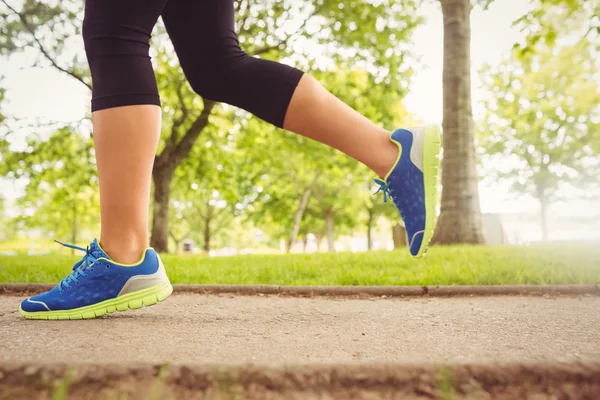 Vrouw dragen van sportschoenen joggen in het park — Stockfoto