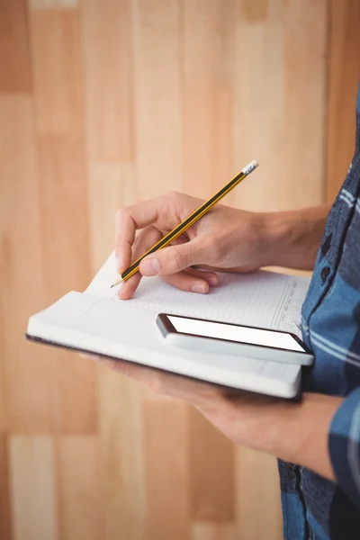 Beskuren bild av man skriver om dagbok med penna — Stockfoto