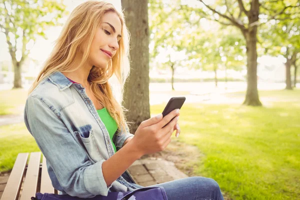 Schöne Frau benutzt Smartphone im Park — Stockfoto