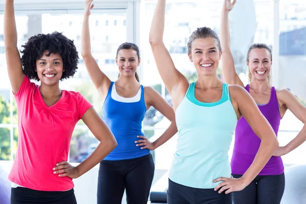 Portret van vrouwen één arm opheffen en glimlachen — Stockfoto