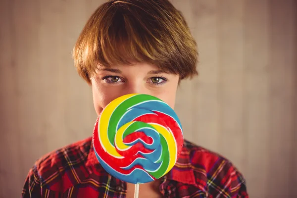 Vacker kvinna gömmer sig hennes ansikte bakom lollipop — Stockfoto